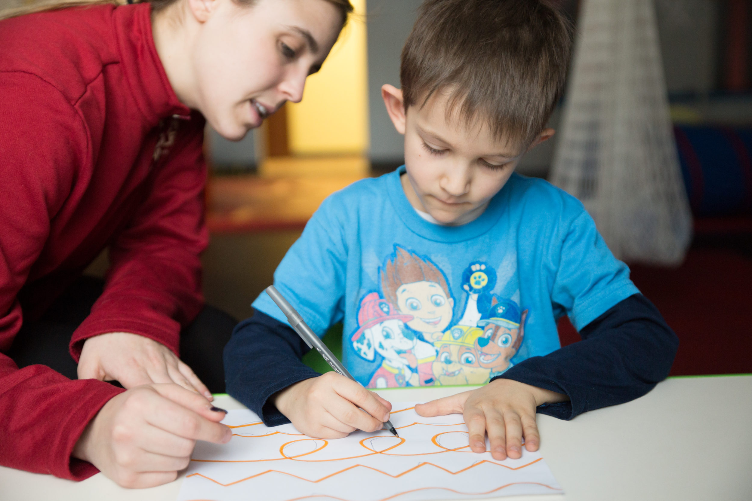 an aba therapist at westside helps a child with a drawing exercise
