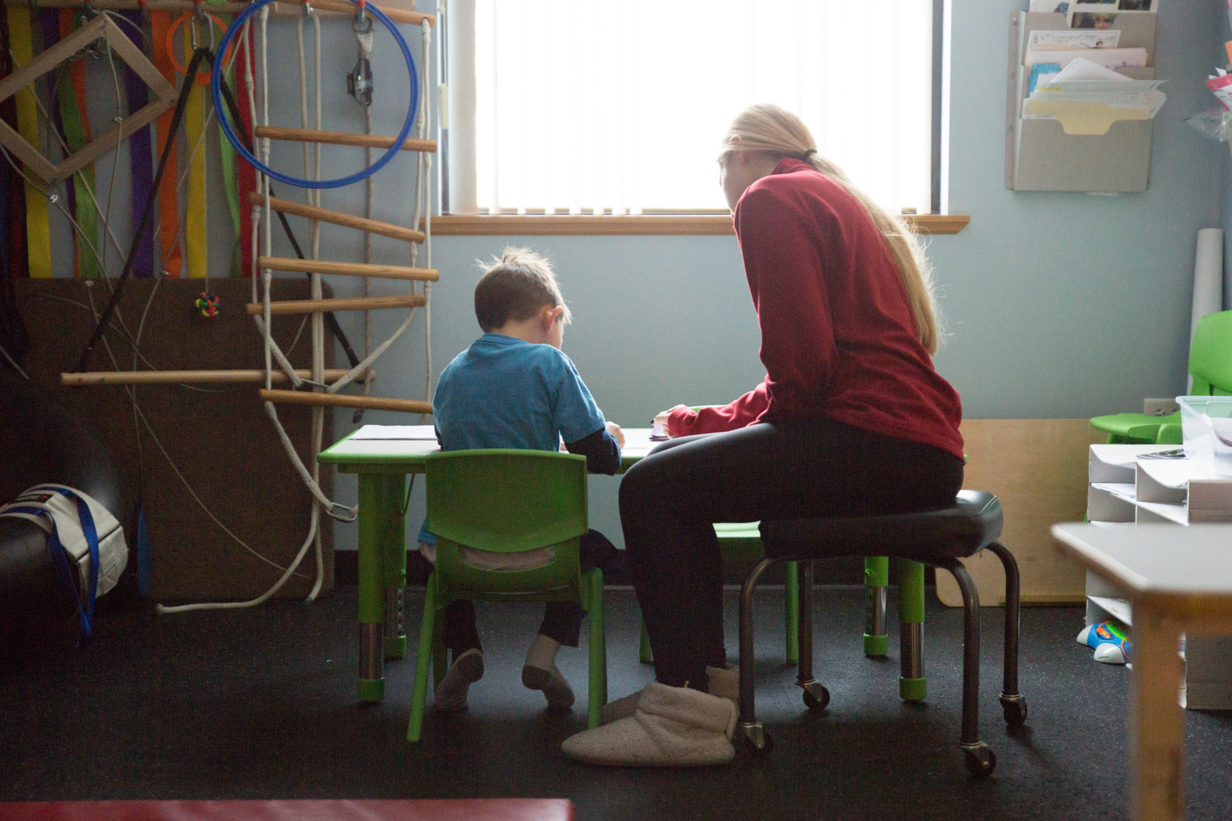 Photo of a child and an ABA therapist during the evaluation process to determine how many hours is needed for ABA - Illinois