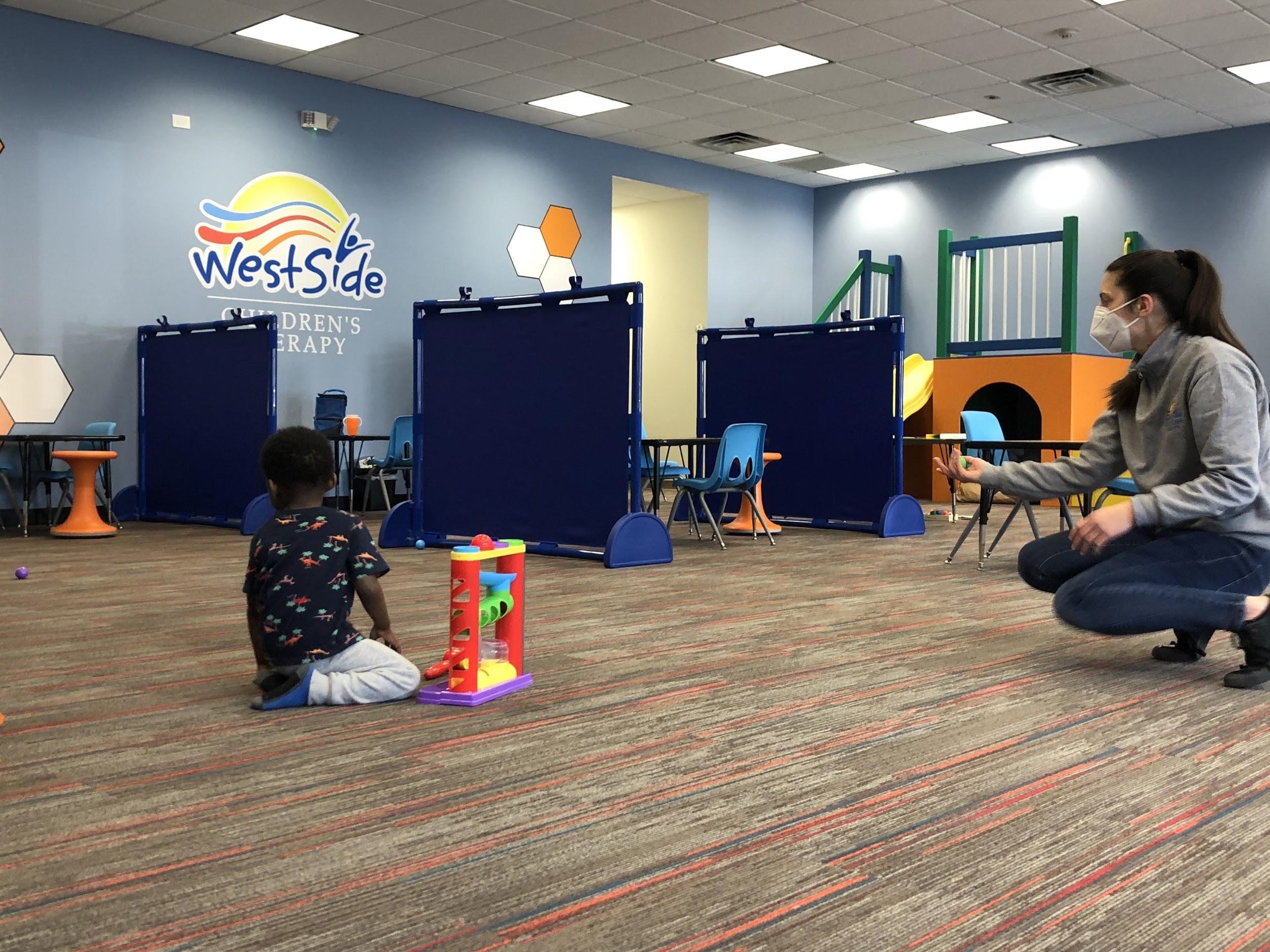 picture of a child during an activity in-clinic therapy, as opposed to in-home therapy.  This picture is taken at Westside Children's Therapy in Illinois