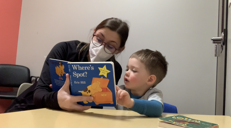 photo of a therapist and a child reading where's spot in a Westside clinic in Illinois