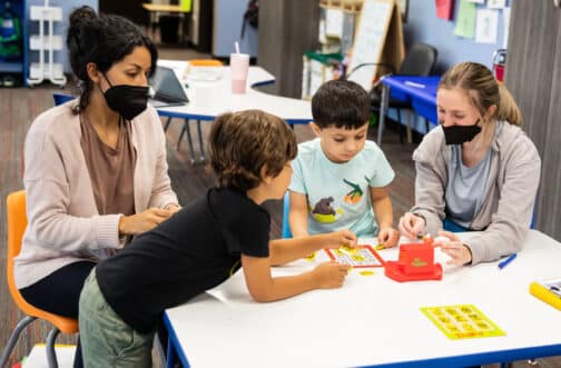 Two kids work with their therapists in Westside's IGNITE ABA Program.