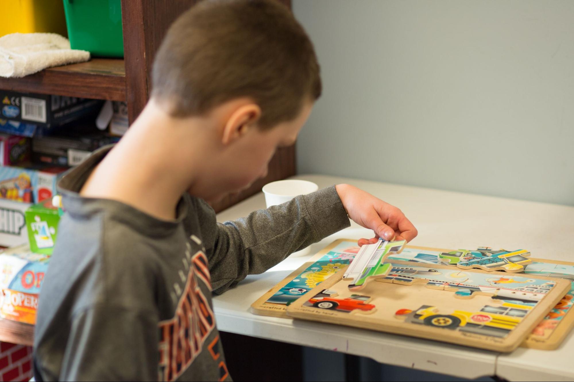 child at westside figuring out puzzle for autism therapy activity, photo used for 7 common misconceptions of aba therapy blog