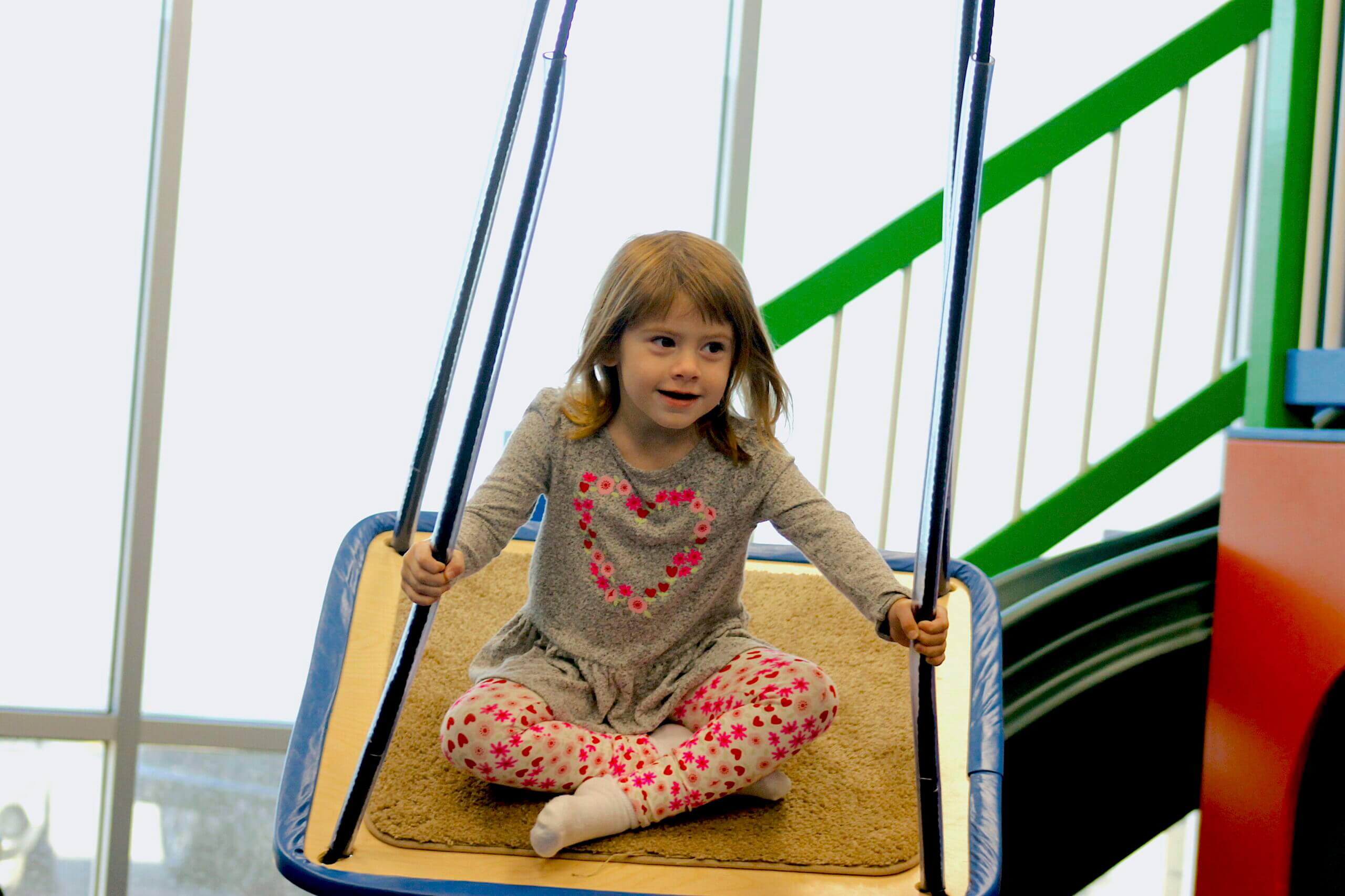 Child with autism in sensory swing