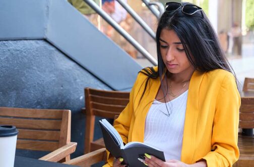Mother reading book by coffee shop