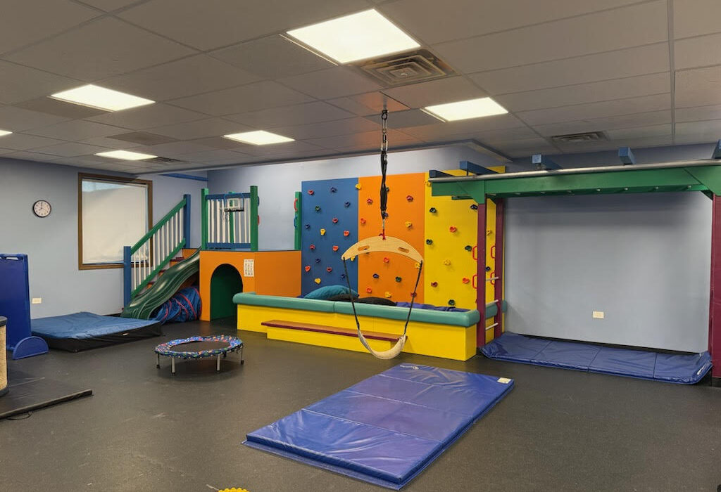 indoor pediatric sensory or occupational therapy gym equipped with colorful climbing structures