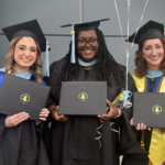Three Westside Children's Therapy RBTs in graduation caps and gowns holding NIU diplomas after completing the Westside NIU BCBA cohort program.