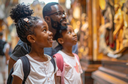 A father and two children looking up with wonder during a museum visit, representing sensory-friendly and inclusive events for families in the Chicago area.