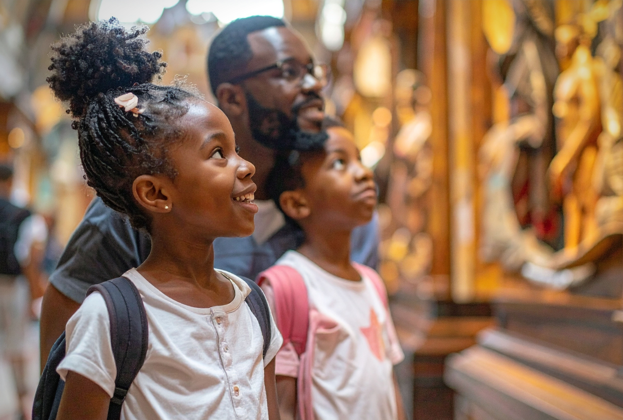 A father and two children looking up with wonder during a museum visit, representing sensory-friendly and inclusive events for families in the Chicago area.