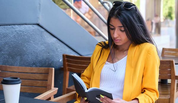 Mother reading book by coffee shop